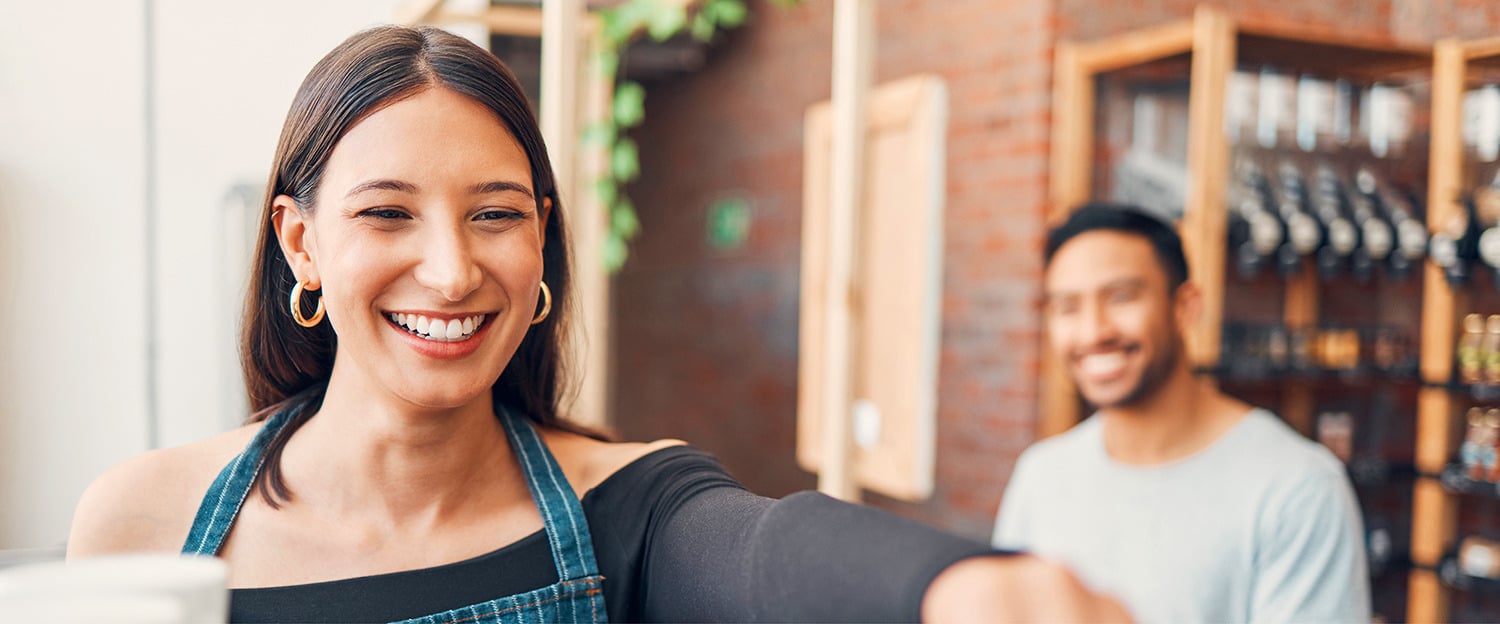 A restaurant worker smiles at the camera